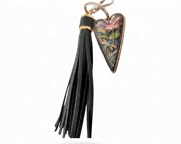 dragonfly resin keychain with a pressed pink rose and colorful dragonfly in a smoky heart, finished with a black leather tassel