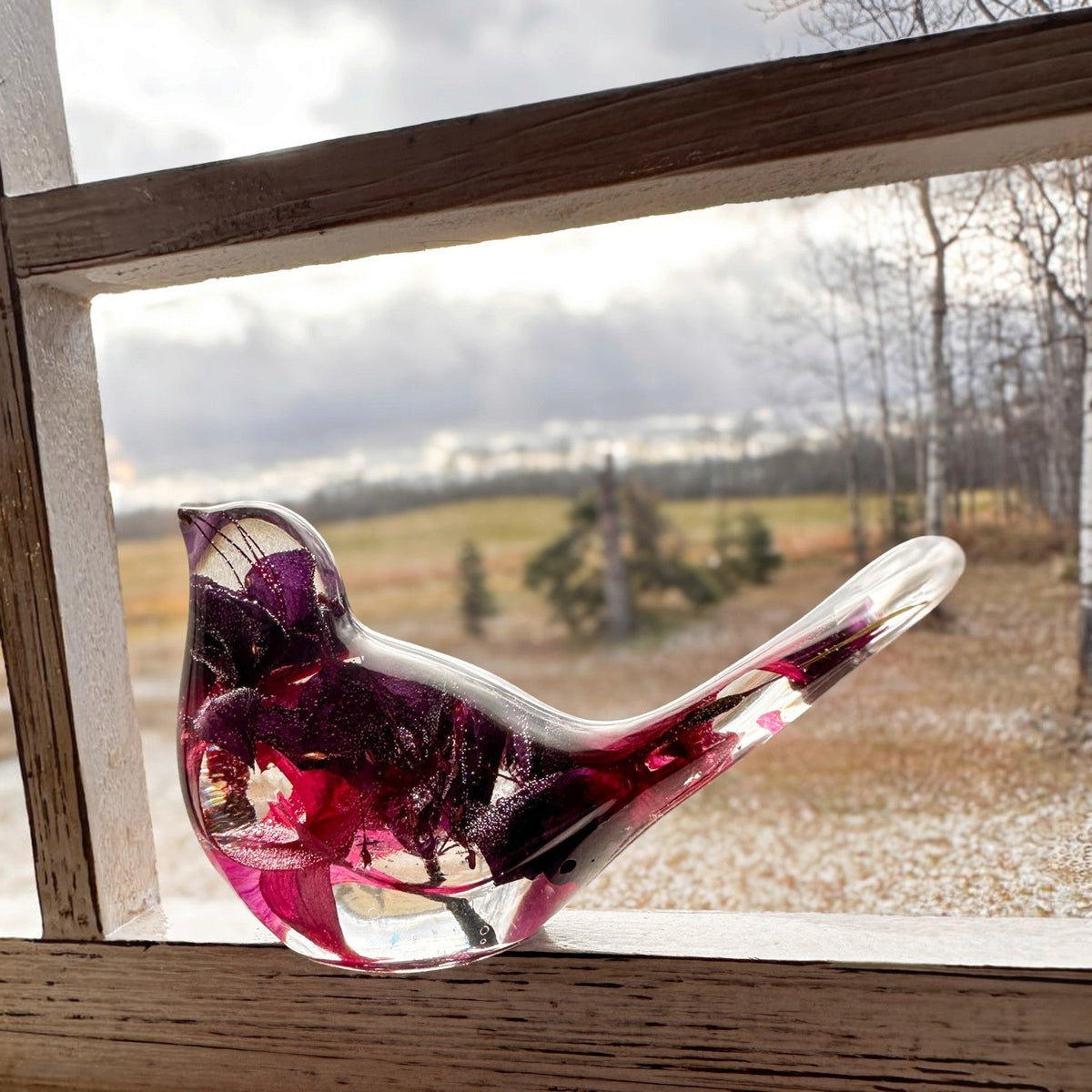 Fuchsia resin bird decor with clear glossy resin, deep purple and crimson pink preserved blooms, and a long transparent tail.