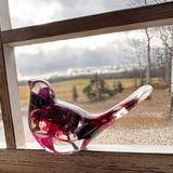 Fuchsia resin bird decor with clear glossy resin, deep purple and crimson pink preserved blooms, and a long transparent tail.