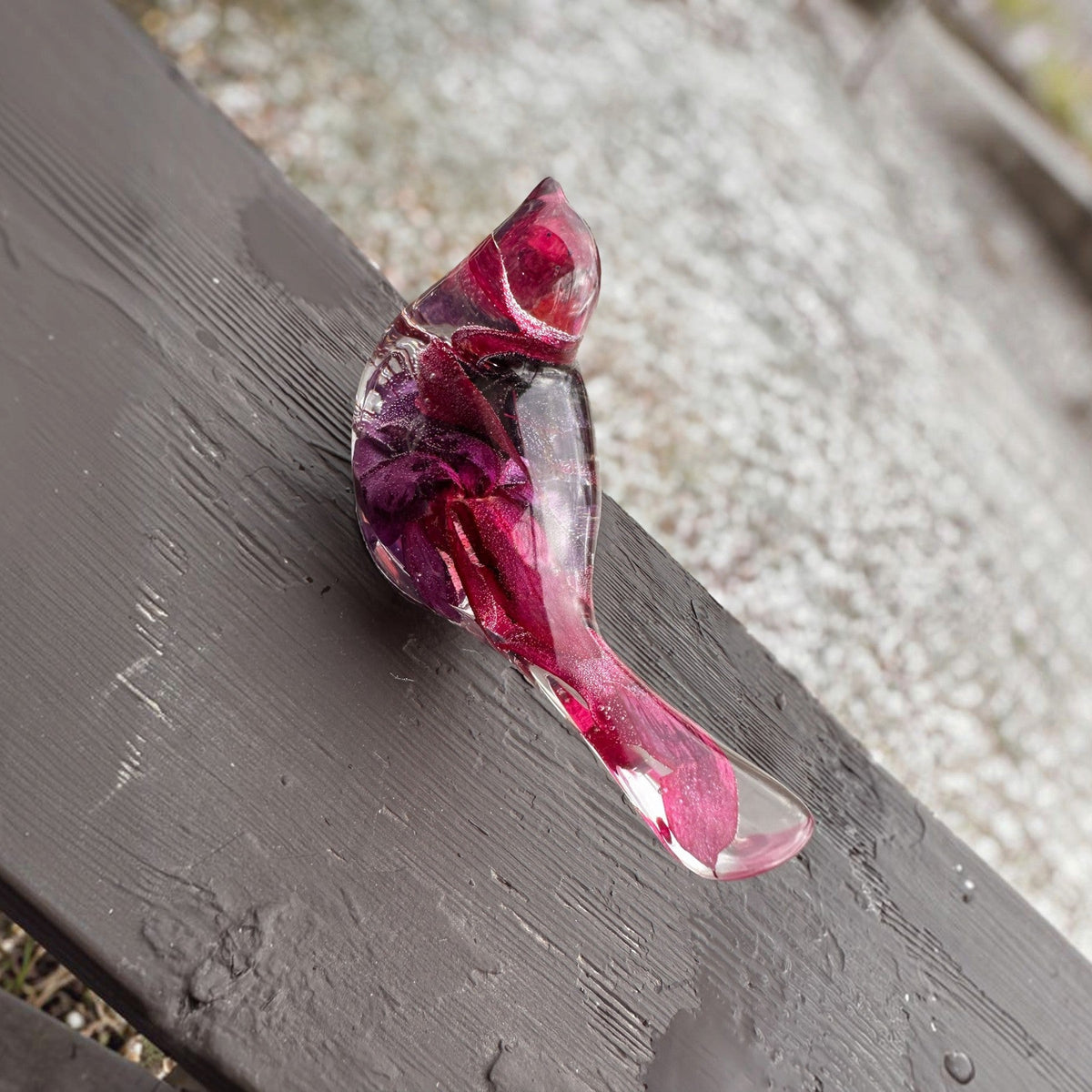 Fuchsia resin bird decor with clear glossy resin, preserved purple and crimson blooms, and a translucent pink tail.