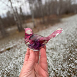 Fuchsia resin bird decor with clear glossy resin, embedded deep purple and pink petals, and a long upturned tail.