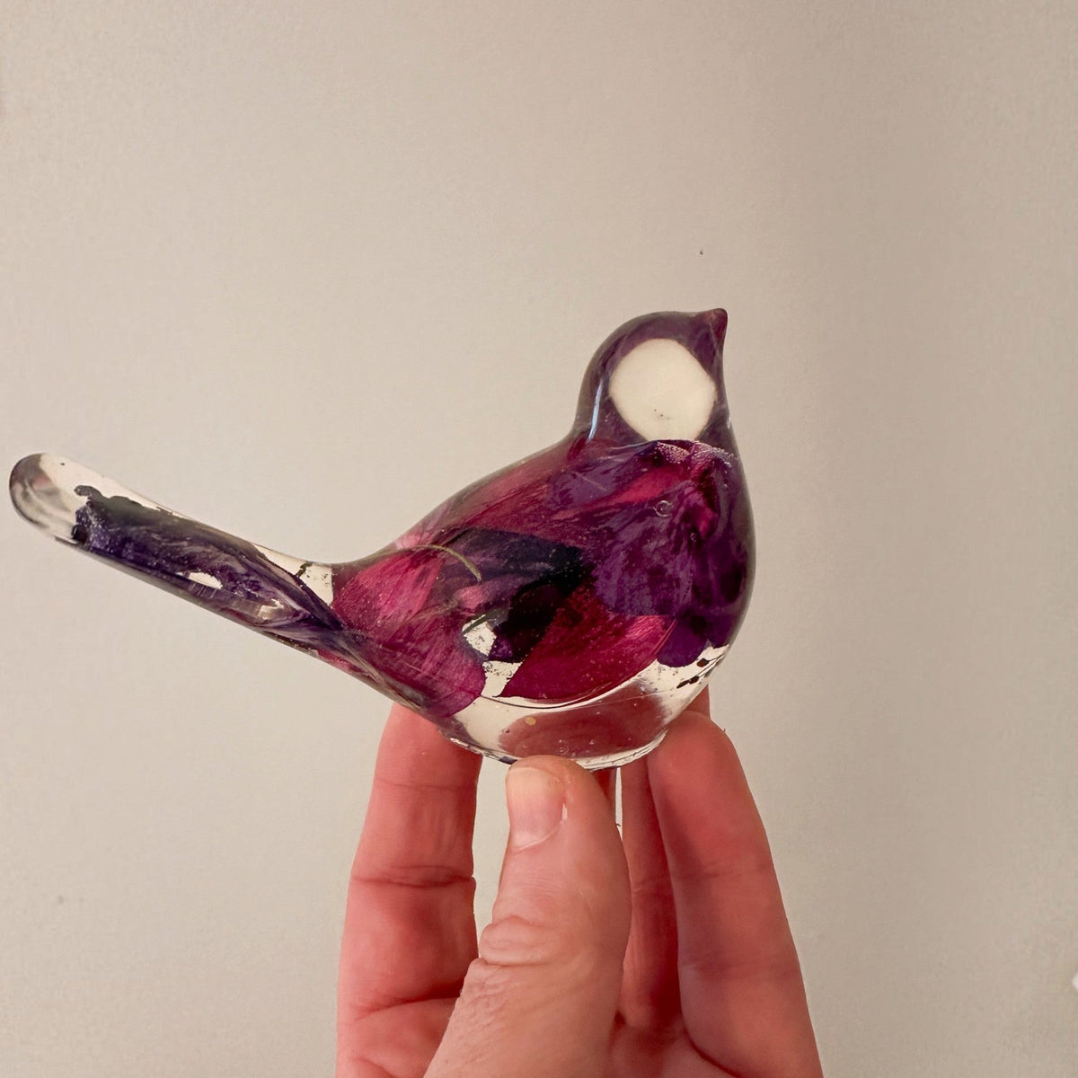 Fuchsia resin bird decor with deep purple and crimson preserved blooms in a glossy clear body and tail, plus a clear head.