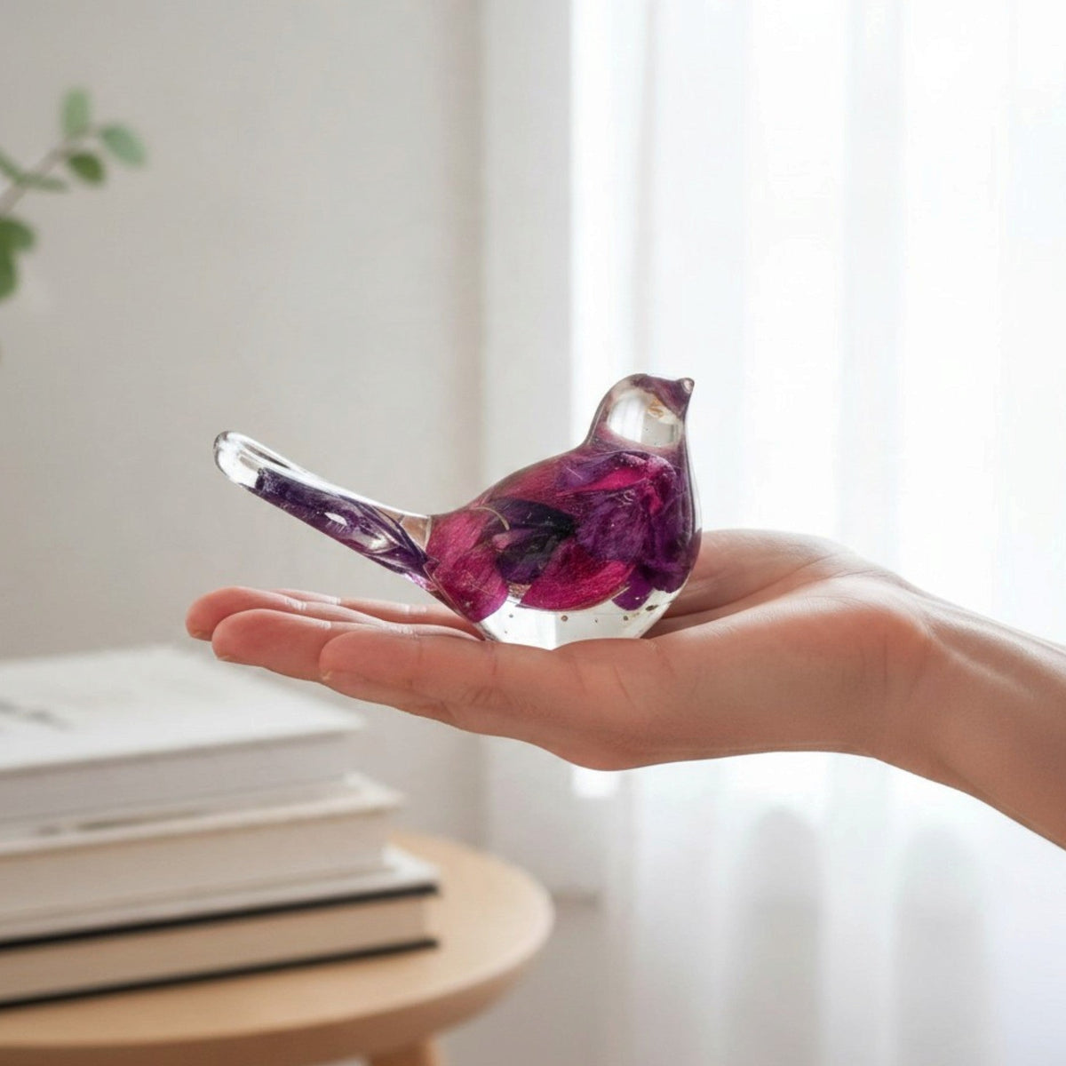 Fuchsia resin bird decor with clear glossy resin, deep purple and magenta preserved petals, and a long transparent tail.