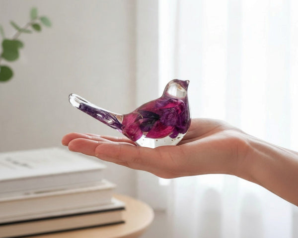 Fuchsia resin bird decor with clear glossy resin, deep purple and magenta preserved petals, and a long transparent tail.