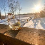 Gold leaf resin bird on a windowsill with winter sun coming through the resin