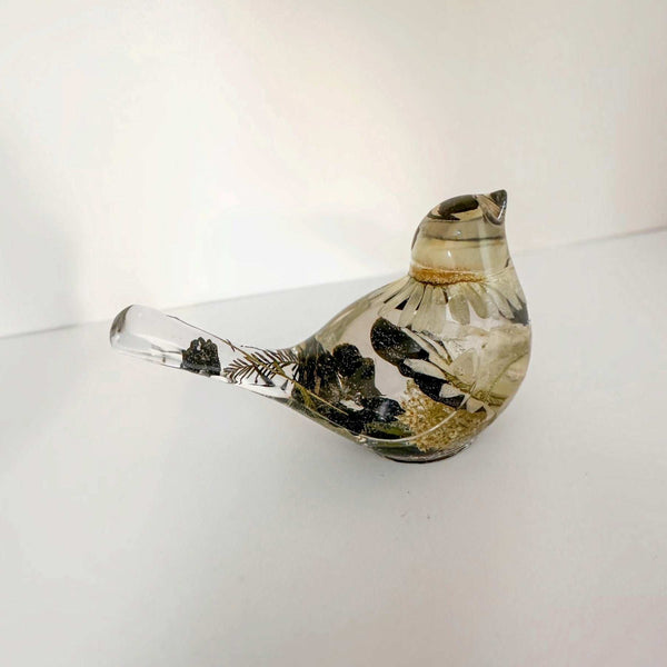 Close up of a handmade chickadee showing black and white dried blooms in resin
