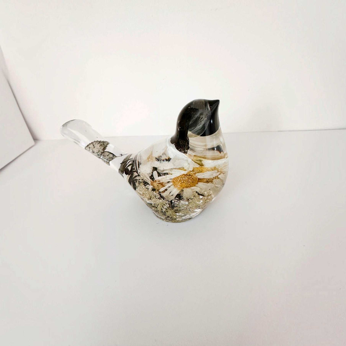 Handmade chickadee resin bird showing flower placement across the back