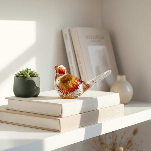 Harvest Songbird strawflower resin bird decor perched on a shelf with loose dried strawflowers