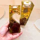 heart tealight holder set in clear amber resin with dried yellow sunflowers, deep red roses and two interlocking pieces