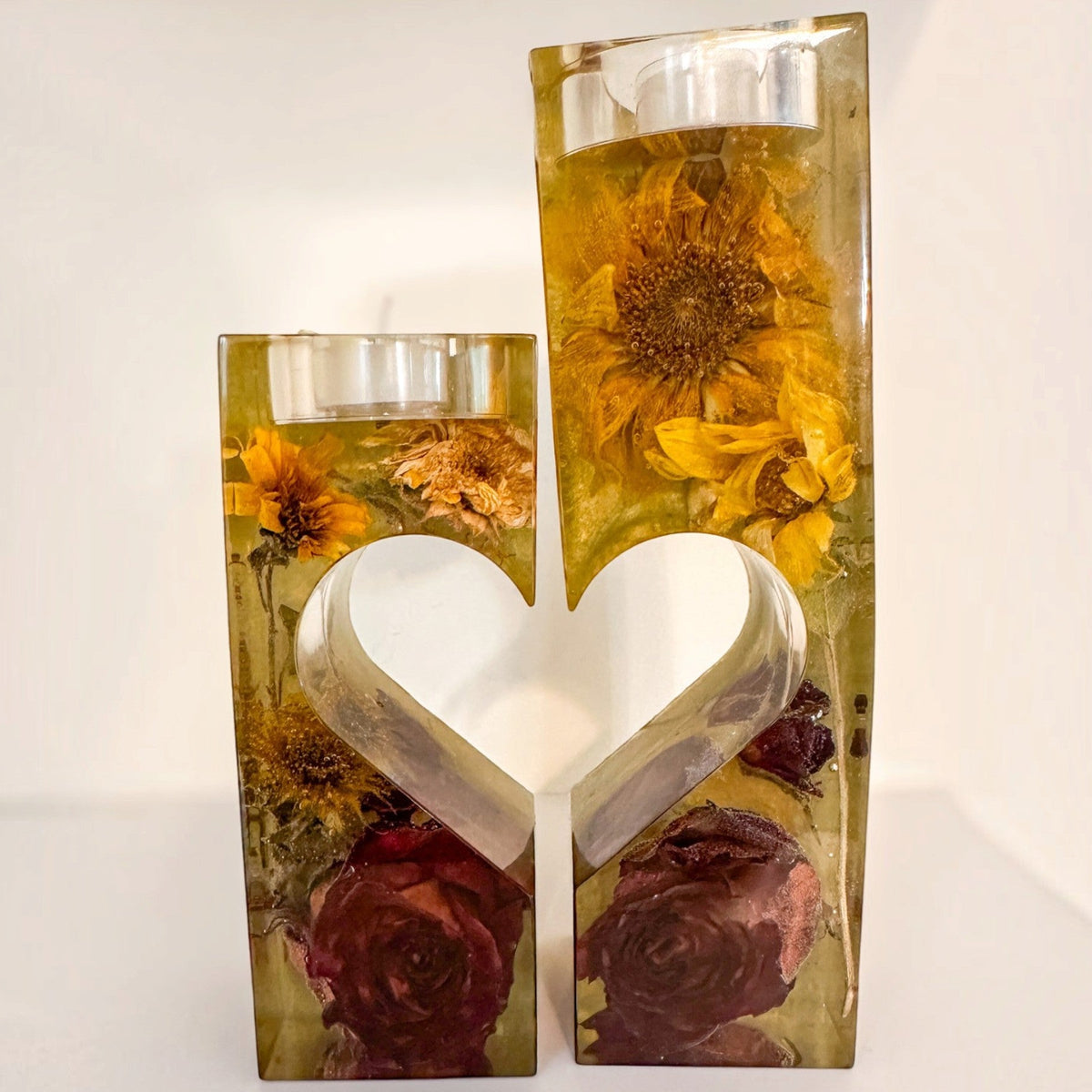 Heart tealight holder set with two clear resin pieces, golden dried sunflowers, deep red roses, and heart-shaped inner edges