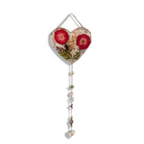 Pressed rose suncatcher featuring two deep crimson roses, green leaves, silver leaf flakes in clear resin, with silver chain and crystal charms.