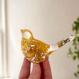 Yellow Strawflower Resin Bird with clear resin, honey-gold dried flowers, and a transparent tail holding a small bud.