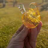 Yellow Strawflower Resin Bird figurine in clear amber resin with layered golden dried flowers and a transparent tail.