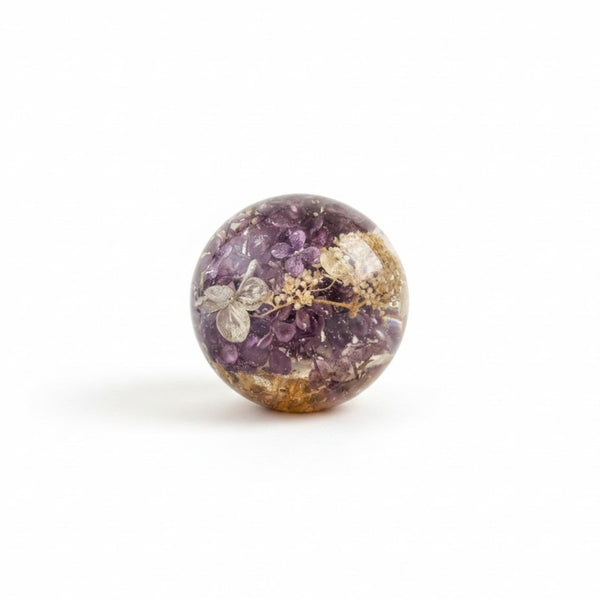 Purple lilac resin sphere with real lilac and hydrangea flowers illuminated on LED base
