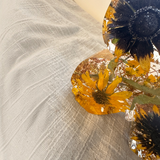 Light up resin butterfly decor with clear amber resin wings, preserved yellow sunflower petals, dark centers, and green botanicals