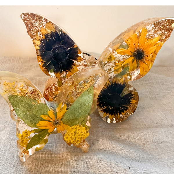 Light up resin butterfly decor set with two clear resin butterflies, featuring golden flowers, green leaves and gold flecks