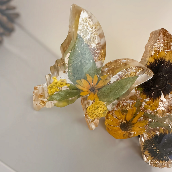 Light up resin butterfly decor set in clear resin with yellow flowers, green leaves, gold flecks and dark flower centres
