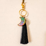 Luna Glow crescent moon keychain in shimmering pink, green and purple resin with gold-tone frame and black tassel