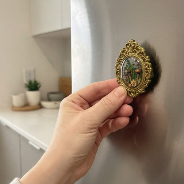 Mushroom fridge magnet held in hand to show its 2.5 inch size against a stainless steel fridge