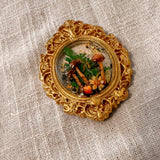 Detail of the ornate gold scrollwork frame on the mushroom fridge magnet