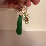 Mushroom owl keychain with green tassel, lobster clasp and keyring laid flat