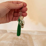 Silver mushroom owl keychain held in a hand showing its 2 inch size