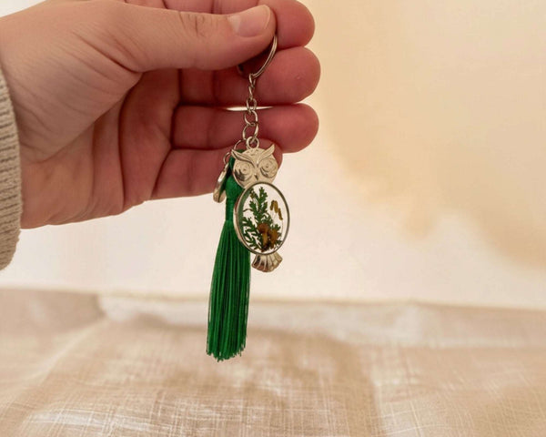 Silver mushroom owl keychain held in a hand showing its 2 inch size