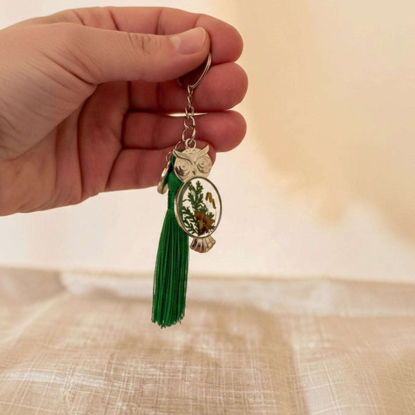 Silver mushroom owl keychain held in a hand showing its 2 inch size