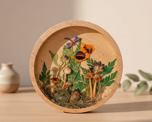 mushroom trinket dish in a round natural wood rim with clear resin, raised mushrooms, moss, ferns and bright flowers
