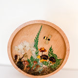 Mushroom trinket dish in a round natural wood rim with clear resin, tiny mushrooms, pressed flowers, greenery and a bee charm