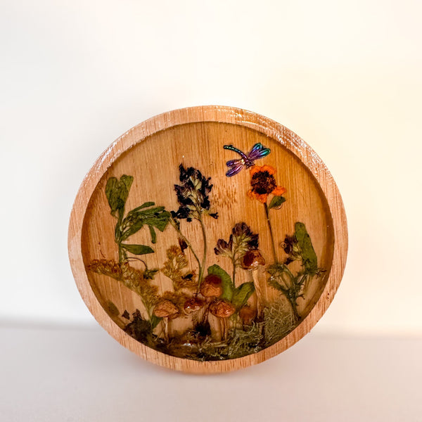 mushroom trinket dish in a round natural wood rim with clear resin, tiny mushrooms, pressed botanicals and a dragonfly