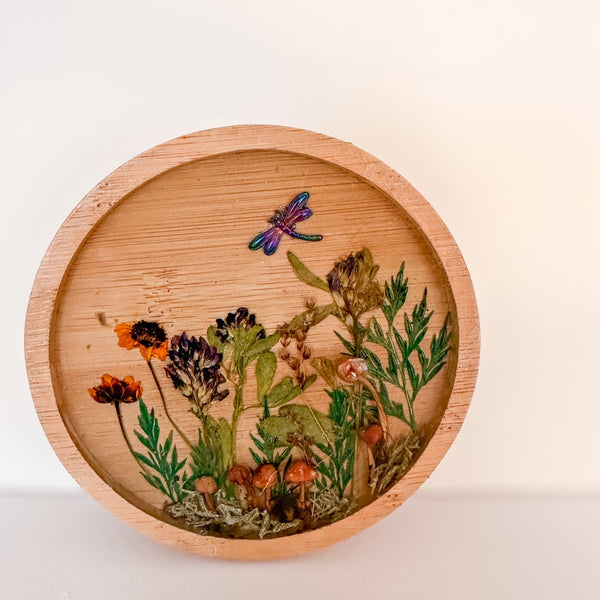 mushroom trinket dish in a round natural wood rim with clear resin, tiny mushrooms, pressed wildflowers and a dragonfly