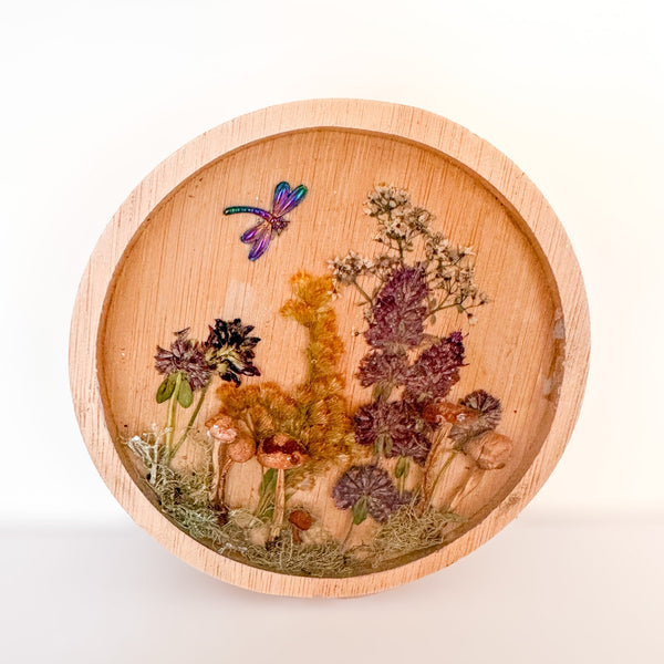 mushroom trinket dish in natural round wood with clear resin, raised mushrooms, pressed botanicals and a dragonfly