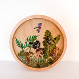 Mushroom trinket dish in natural round wood with clear resin, raised mushrooms, pressed ferns and a purple dragonfly charm