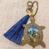 Ocean Keeper sea turtle keychain with antique bronze turtle frame, dark blue tassel and ocean-toned resin center
