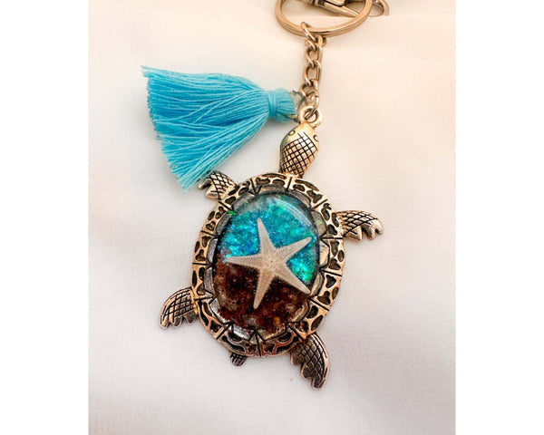 Ocean Keeper sea turtle keychain with antique bronze metal, turquoise and brown resin, sand, and a starfish charm