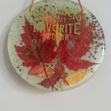 October Glow round resin wall art with red and gold pressed maple leaves, copper glitter and gold lettering
