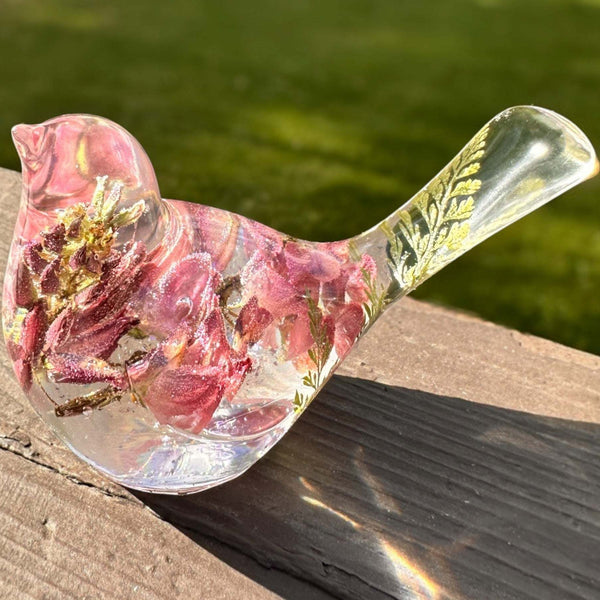 pink lupine resin bird decor with clear resin, layered pink flowers, a fern in its tail, and glitter along the base.