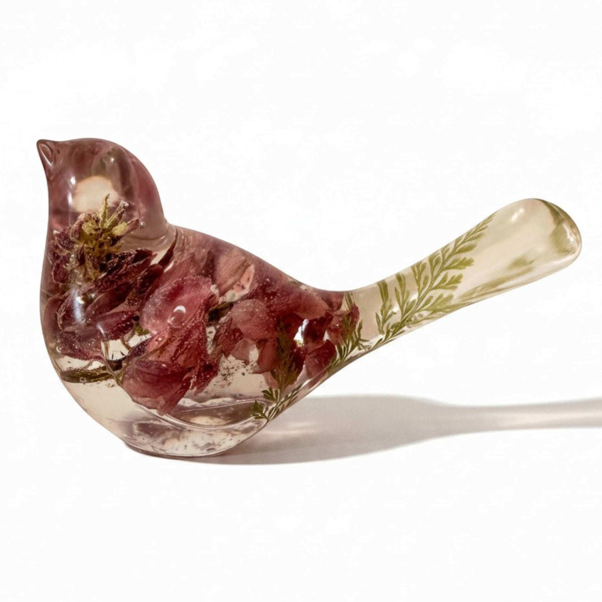 Pink lupine resin bird decor, translucent bird with mauve dried flowers, pale green foliage in the tail, and clear resin body.
