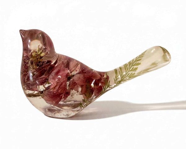 Pink lupine resin bird decor, translucent bird with mauve dried flowers, pale green foliage in the tail, and clear resin body.