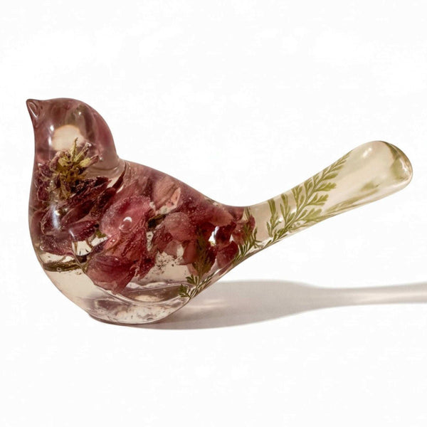 Pink lupine resin bird decor, translucent bird with mauve dried flowers, pale green foliage in the tail, and clear resin body.