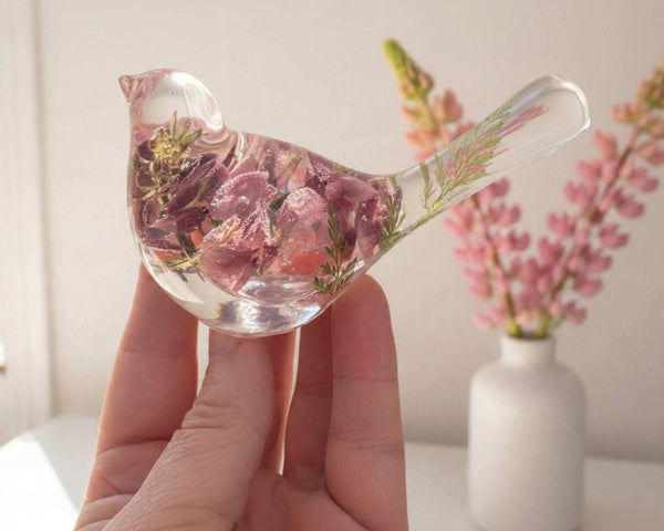 pink lupine resin bird decor in clear resin, with dimensional rose and dusty pink blooms and a green fern in its tail