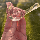 Pink lupine resin bird decor with translucent clear resin, pink dried flowers, green foliage in the tail, and a glittered base