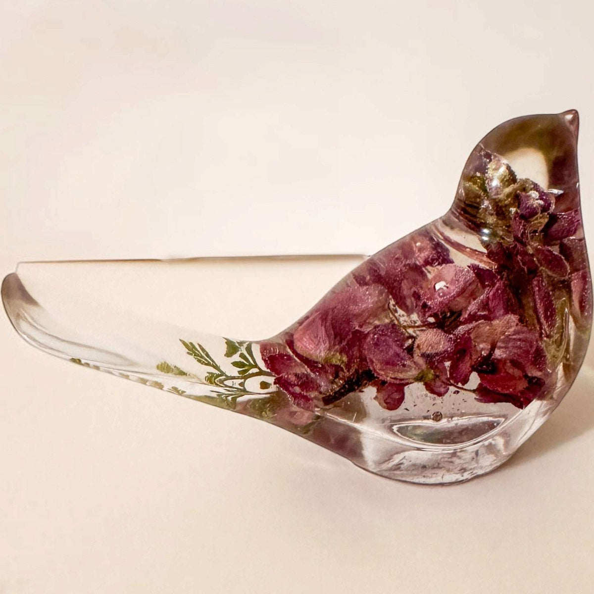 pink lupine resin bird decor with deep rose dried flowers, green fern in a clear resin tail, and a glossy finish