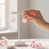 Close up of dark pink Queen Anne's Lace and a tiny floating butterfly inside pink floral butterfly earrings.