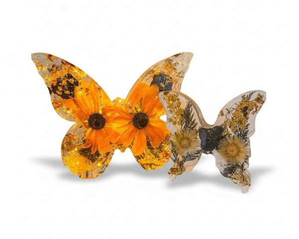 Light up resin butterfly decor set with two clear resin butterflies, orange blooms, dried flowers, and gold leaf‑style accents.