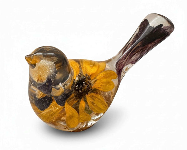 Resin songbird decor, Harvest Lupine Songbird, clear amber-toned with embedded yellow flowers, dark petals, and a purple-streaked tail.