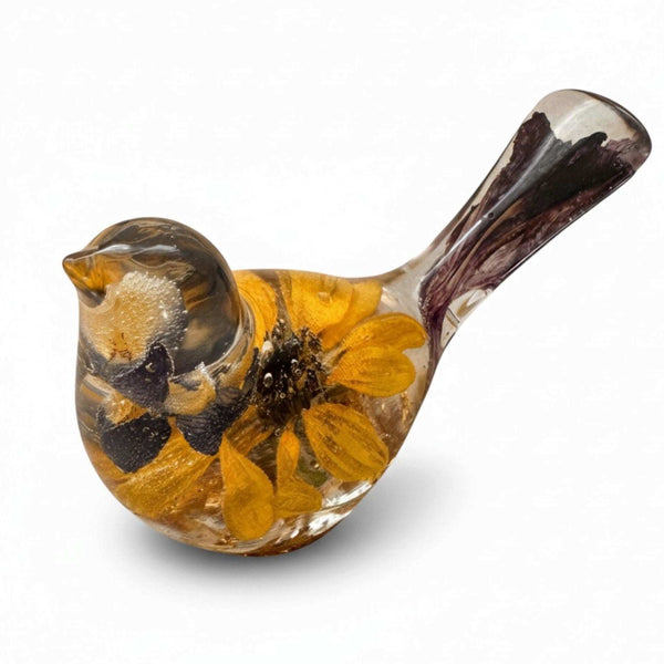 Resin songbird decor, Harvest Lupine Songbird, clear amber-toned with embedded yellow flowers, dark petals, and a purple-streaked tail.
