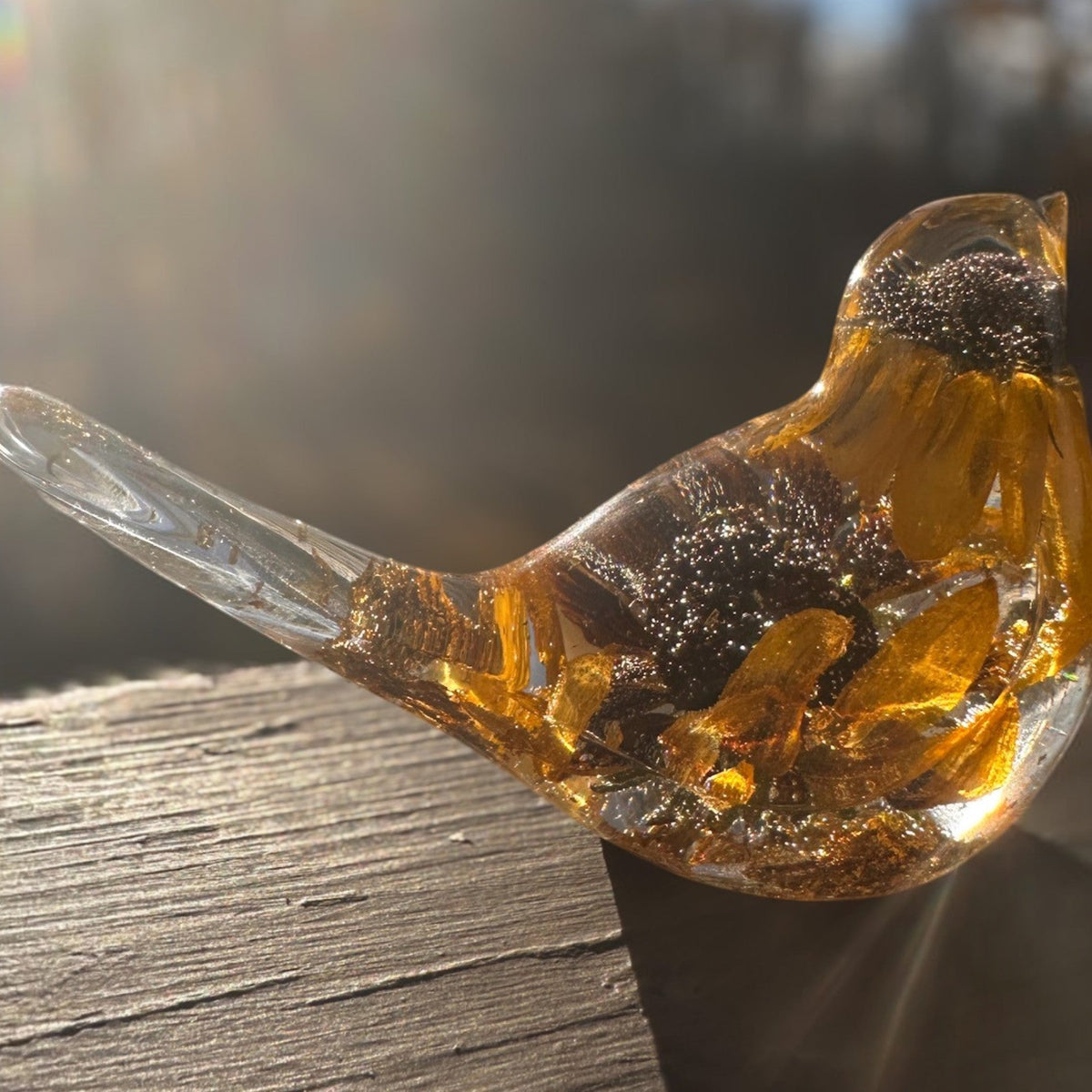 Black eyed susan resin bird with amber-clear resin, golden petals and dark brown flower centres, in a rounded shape with a clear tail.
