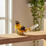 Black eyed susan resin bird in clear resin with golden petals, dark brown centres and a translucent gold-flecked tail
